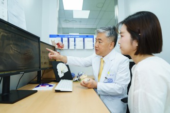 서울대치과병원 구강내과 정진우 교수(왼쪽)가 환자를 진료하면서 증상에 대해 설명하고 있다.