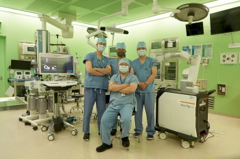 신경외과 손동욱 교수(앞줄)와 오부광 교수, 이수헌 교수, 이준석 교수(뒷줄 왼쪽부터)가 CUVIS-spine 로봇 척추 수술기구 옆에서 기념촬영을 하고 있다.