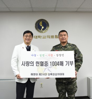 옥윤호 해병대 제2사단 대대장(오른쪽)이 박준성 아주대병원장에게 헌혈증을 전달하고 있다.